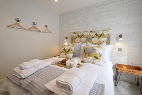 ein Schlafzimmer mit zwei Betten mit weißen Laken und Kissen in der Unterkunft 53 Tern Cottage, Aldeburgh in Aldeburgh