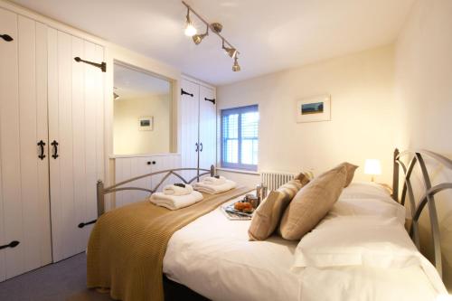 um quarto com uma grande cama branca com toalhas em Smugglers Rest, Aldeburgh em Aldeburgh