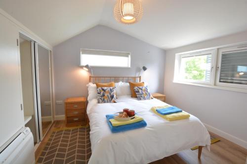 a bedroom with a bed with a tray of food on it at Bramertons Nest, Long Melford in Long Melford
