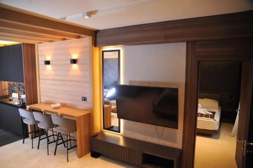 a living room with a television and a table with chairs at Family Apart Woodside in Kopaonik