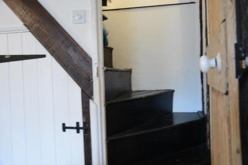 an open door to a room with stairs at The Moorings, Orford in Orford