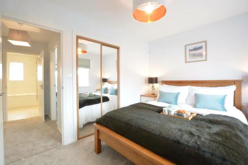 a bedroom with a large bed and a mirror at Lapwings, Aldeburgh in Aldeburgh
