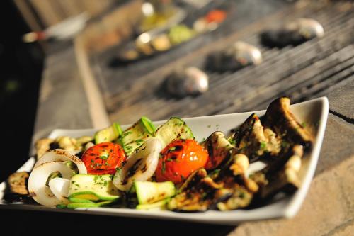 a plate of food with vegetables on a table at Baia Degli Aranci Suite & Apartments in Vieste