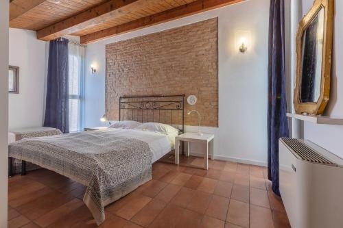 a bedroom with a bed and a brick wall at Francolino Duplex Charming La Farnia Villa in Francolino