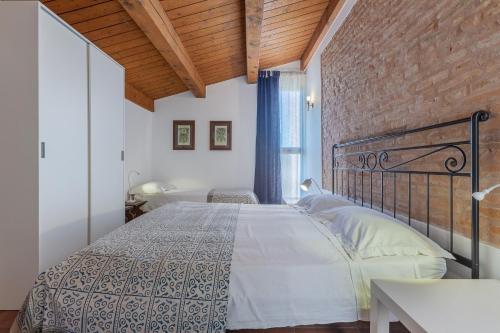 a bedroom with a bed and a brick wall at Francolino Duplex Charming La Farnia Villa in Francolino