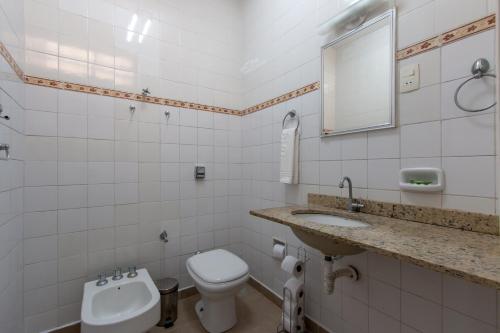 a white bathroom with a toilet and a sink at Casa no Tatuapé com Garagem e Portão Automático in São Paulo