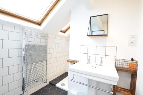 uma casa de banho com um lavatório e um espelho em Blackshore House, Wenhaston em Southwold