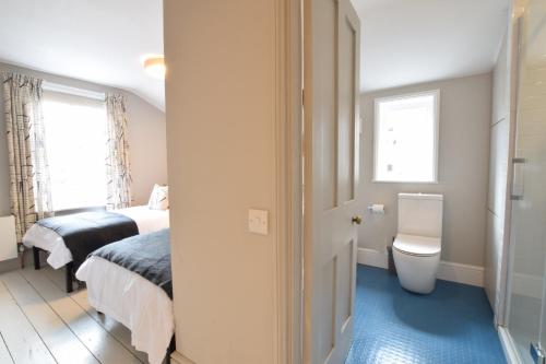a bedroom with a bed and a toilet and a window at 37 Stradbroke Road, Southwold in Southwold