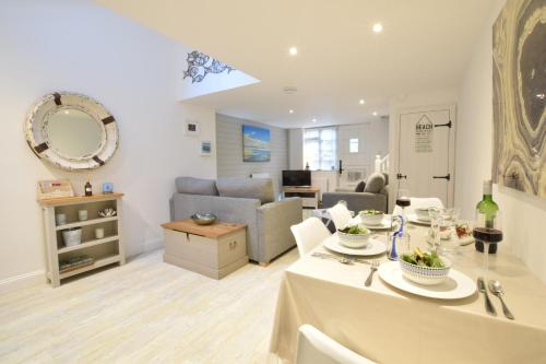 a living room with a table and a couch at The Smokehouse Cottage in Southwold