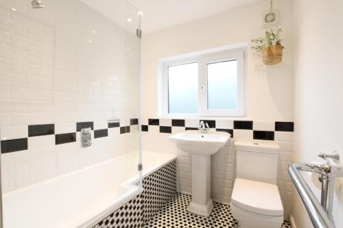 a bathroom with a sink and a toilet and a bath tub at Marsh View, Southwold in Southwold