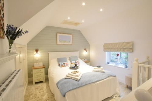 1 dormitorio con 1 cama con toallas en The Smokehouse Cottage en Southwold