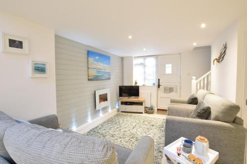 a living room with a couch and a tv at The Smokehouse Cottage in Southwold