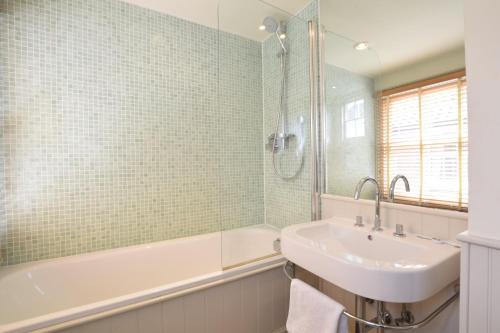 a bathroom with a sink and a bath tub and a sink at 14 Dunwich Road, Southwold in Southwold