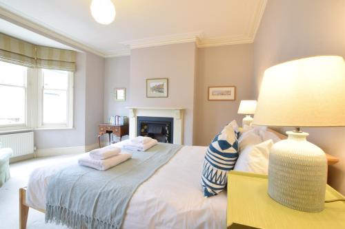 a bedroom with a bed with a lamp on a table at 14 Dunwich Road, Southwold in Southwold