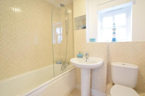 a bathroom with a sink and a toilet and a shower at Bluebelle Cottage, Peasenhall in Peasenhall