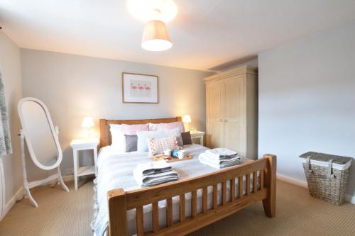 a bedroom with a large bed with a wooden frame at Satis Cottage, Westleton in Westleton