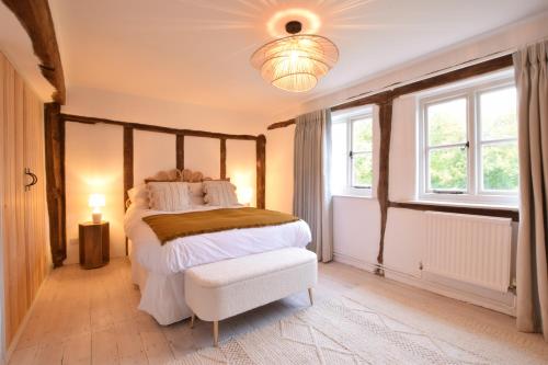 a bedroom with a bed and a chandelier at Old Bloxhall House, Hitcham in Lavenham