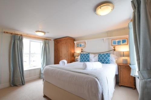 um quarto com uma cama grande e uma janela em 5 Blackshore, Southwold em Southwold