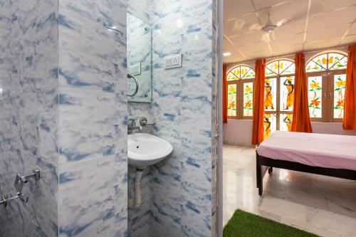 La salle de bains est pourvue d'un lavabo, d'une douche et d'un lit. dans l'établissement An Authentic Village Farm, à Jhansi