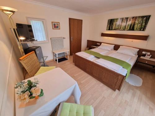 ルーポルディングにあるParkhotel Ruhpoldingの大きなベッドとテーブルが備わるホテルルームです。