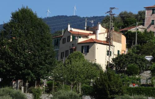 ein Haus an der Seite eines Hügels mit Bäumen in der Unterkunft A ca' du Risso - Appartamento - Sea & outdoor for families, bikers and climbers in Calice Ligure