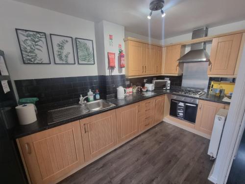 una cucina con armadi in legno e lavandino di Caspian House (4 Bedrooms) a Grimsby