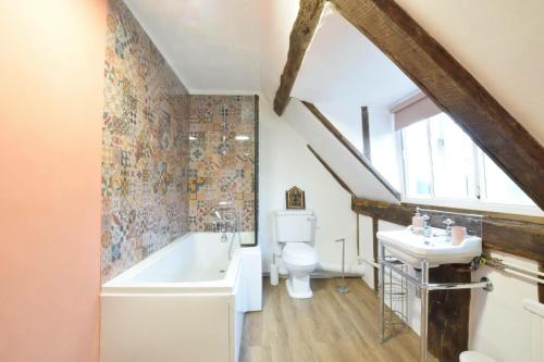ein Badezimmer mit einer Badewanne, einem WC und einem Waschbecken in der Unterkunft Church Farmhouse, Cookley in Halesworth