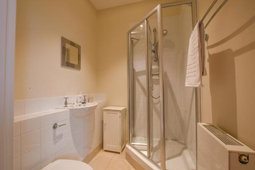 ein Bad mit einer Dusche, einem WC und einem Waschbecken in der Unterkunft 1 Eversley Court, Southwold in Southwold