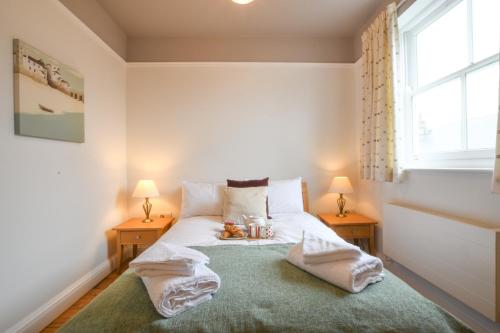 ein Schlafzimmer mit einem Bett mit Handtüchern darauf in der Unterkunft 1 Eversley Court, Southwold in Southwold