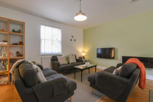 a living room with two couches and a tv at The Gallery, Blythburgh in Blythburgh