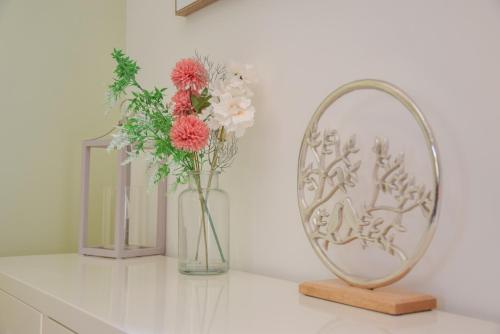 a mirror and a vase with flowers on a counter at The Gallery, Blythburgh in Blythburgh