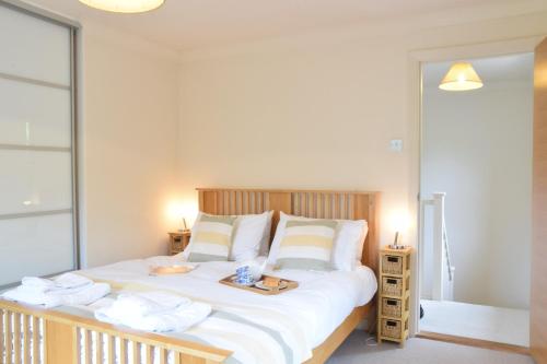 ein Schlafzimmer mit einem großen weißen Bett mit zwei Tischen in der Unterkunft Peach House, Aldeburgh in Aldeburgh