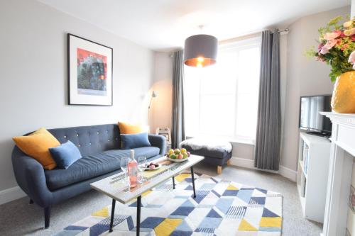 a living room with a couch and a table at Driftwood, Southwold in Southwold