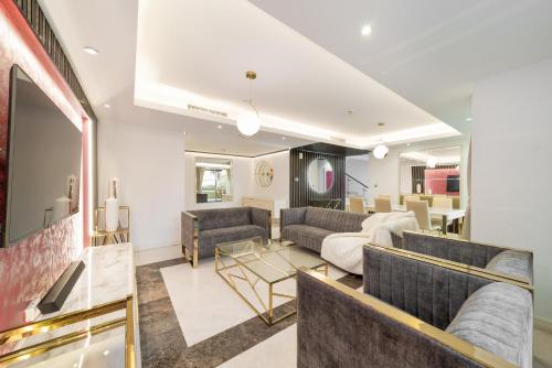 een woonkamer met 2 banken en een tafel bij Elan Suites 5-Bedroom Beach Villa in Dubai