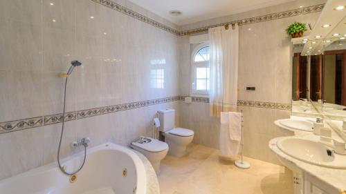 een badkamer met een bad, 2 wastafels en een toilet bij Villa Las Marías Loja by Ruralidays in Loja