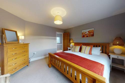 1 dormitorio con 1 cama grande y vestidor en Derwen, en Abersoch