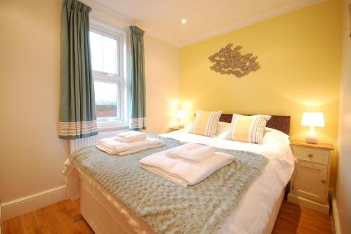 ein Schlafzimmer mit einem Bett mit zwei Handtüchern darauf in der Unterkunft Garden Cottage, Southwold in Southwold