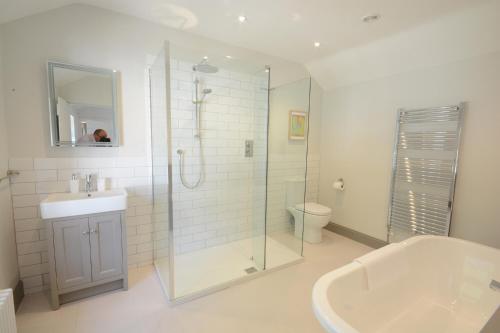 a bathroom with a shower and a sink and a toilet at Fig Cottage, Pettistree in Woodbridge