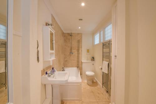 a white bathroom with a sink and a toilet at Beresford House in Woodbridge