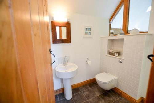 a bathroom with a white sink and a toilet at Three Chantry Barns, Orford in Orford