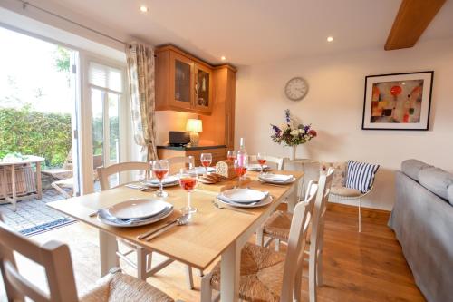 a dining room and living room with a table and chairs at Three Chantry Barns, Orford in Orford