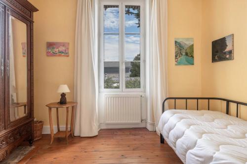 Schlafzimmer mit einem Bett, einem Fenster und einem Tisch in der Unterkunft Maison de caractere a 100 metres de la plage in Le Pouliguen