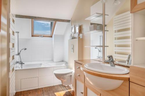 a bathroom with a sink and a toilet and a tub at Maison de caractere a 100 metres de la plage in Le Pouliguen