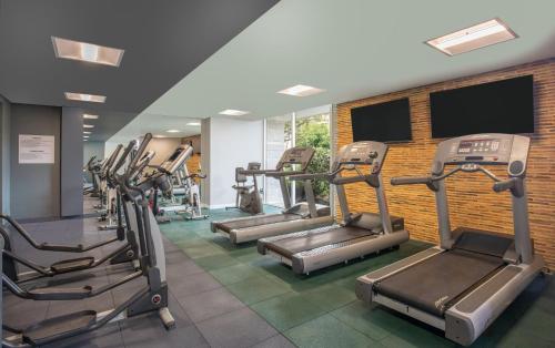 a gym with several tread machines in a room at Holiday Inn Bogota Airport by IHG in Bogotá