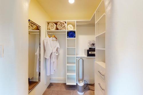 vestidor con armarios blancos y espejo en Cottam Pines A & B, en Taos