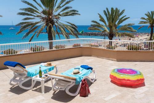 a patio with a table and chairs and the ocean at Apartamentos Vista Sur in Playa de las Americas