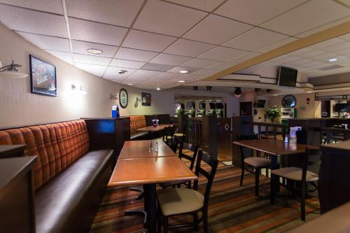 a dining room with tables and chairs in a restaurant at Wyndham Garden Detroit Metro Airport in Romulus