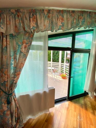 a room with a large window with a view of a patio at Cozy rooms in wine town - Modra in Modra