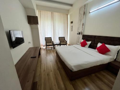 a hotel room with a bed and a table and chairs at Rudraksh Resort and Hotel in Rewāri