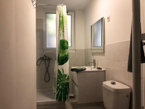 a bathroom with a toilet and a green plant in the shower at T2 entièrement équipé et refait à neuf à 10mn Alès in La GrandʼCombe